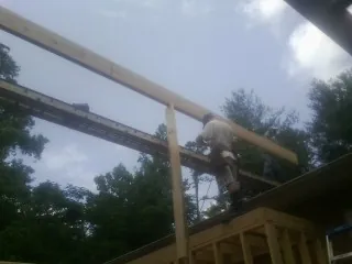 Carpenter setting a ridge beam over a new addition frame — Ice Dam Removal by Roofing Brothers in Ranchos De Taos