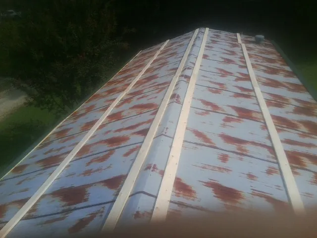 Rusted metal roof panels with new wood purlins before replacement — Storm Damage Roof Repair in Ranchos De Taos by Roofing Brothers